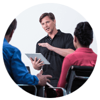Manager Cloud die uitleg geeft aan een team met een tabletcomputer