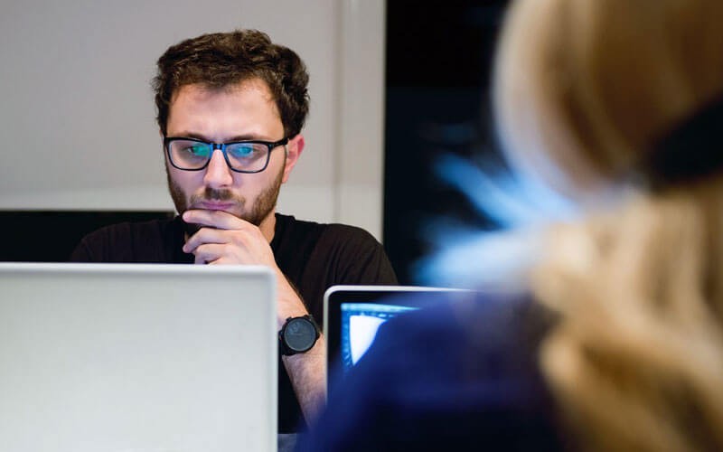 Een man studeert op een laptop