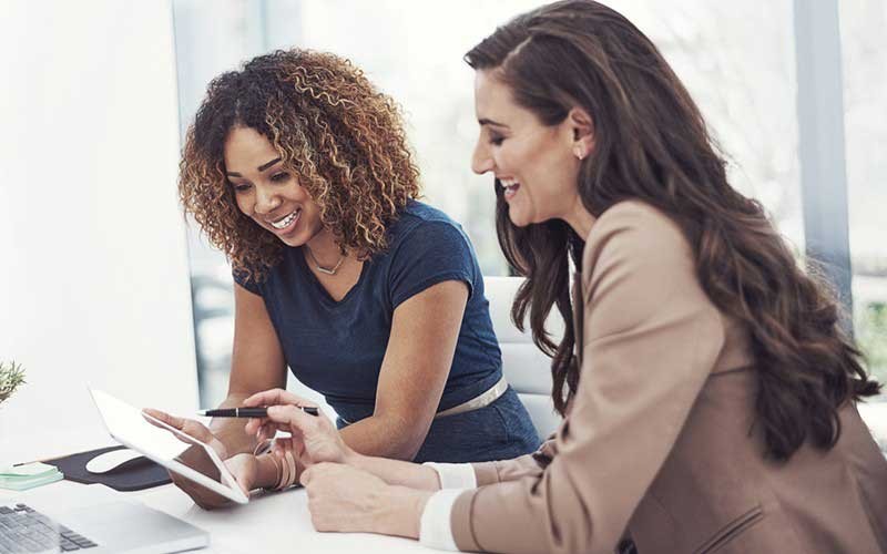 Twee lachende vrouwen mer een tablet-PC
