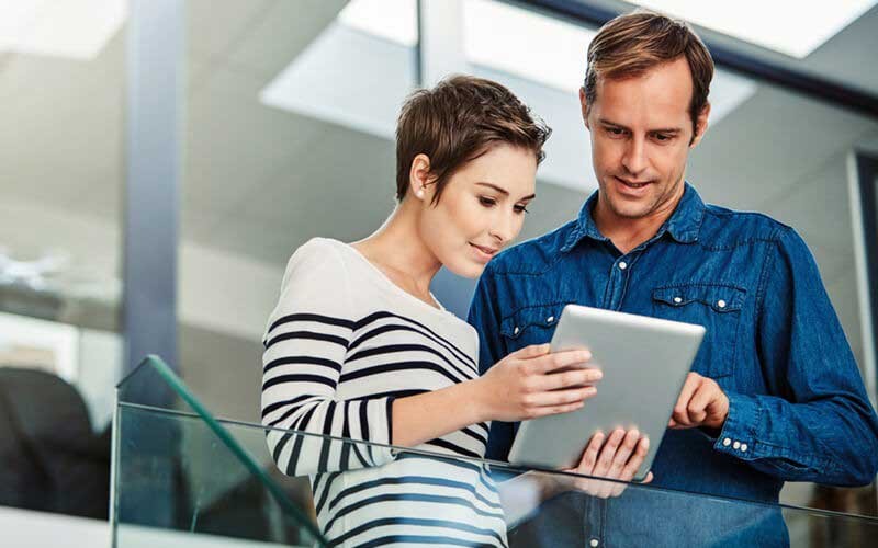 Twee collega's die op een tablet kijken