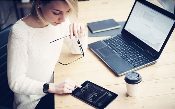 Een jomge vrouw met een Dell laptop en tablet