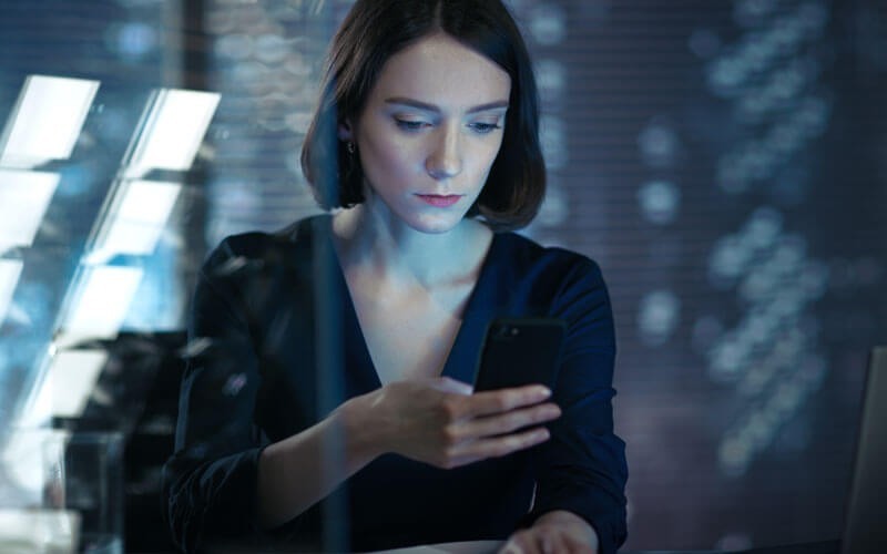 Een vrouw bekijt WhatsApp berichten op haar smartphone
