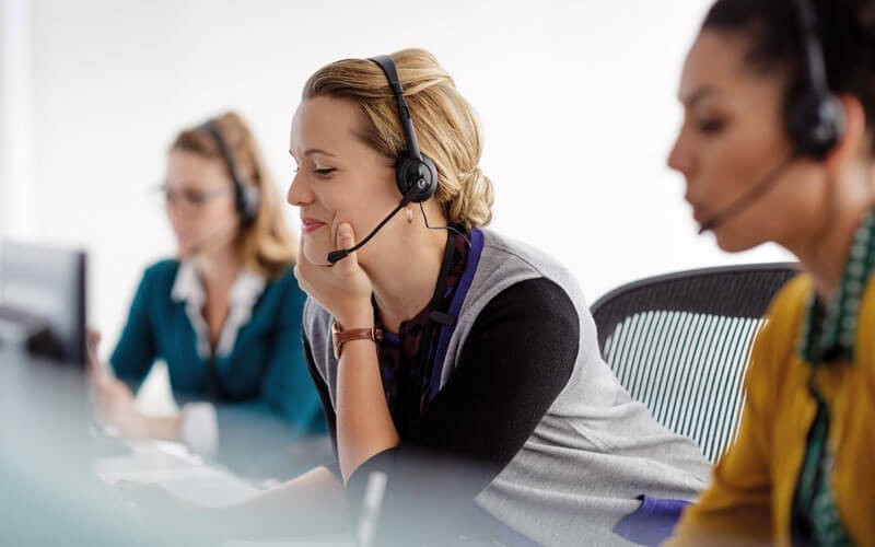 Een helpdesk medewerkster lacht tijdens een gesprek