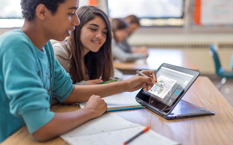 Twee leerlingen gebruiken een stylus pen op een HP touch screen laptop