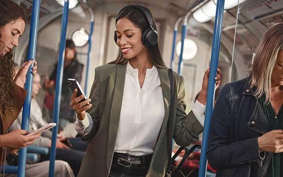Een zakenvrouw gebruikt de Jabra Evolve2 75 in een metro