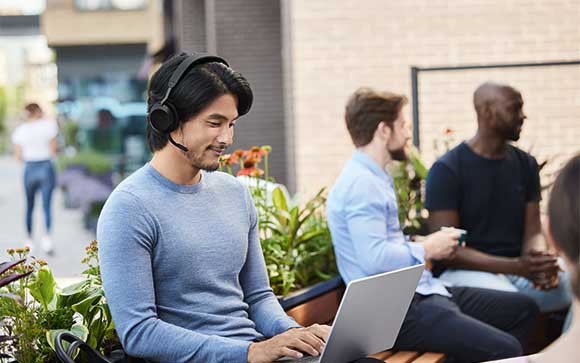 Man werkt in kantoortuin met Jabra Evolve2 75