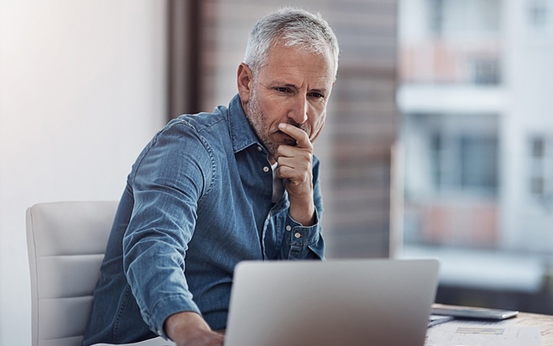 Een man werkt op een laptop
