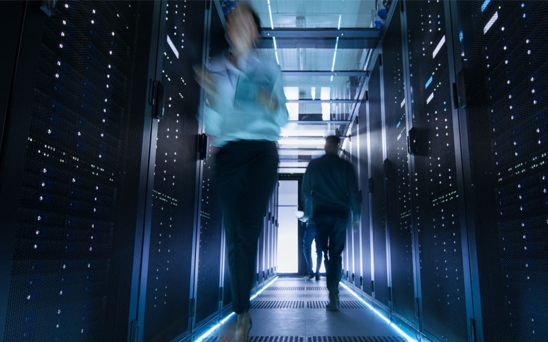Twee mensen lopen door een datacenter