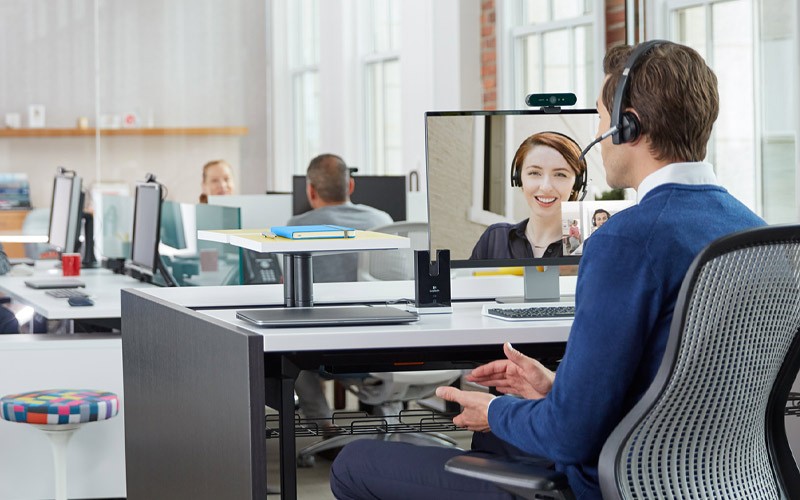 Een man gebruikt een Logitech Headset tijdens een videovergadering