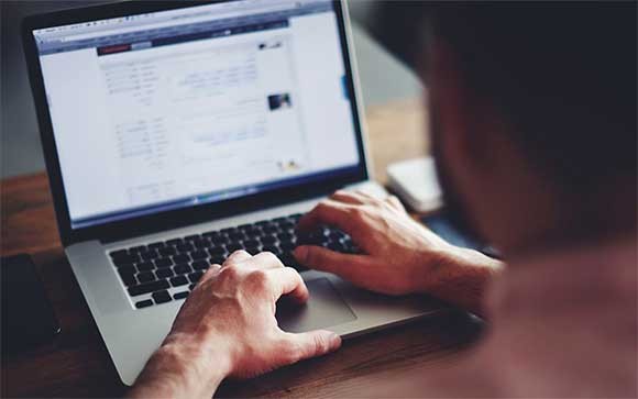 Een man gebruikt een privacy scherm op zijn laptop