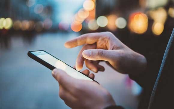 Een man gebruikt zijn smartphone op straat