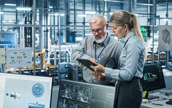 Twee collega's met een tablet bij een productielijn